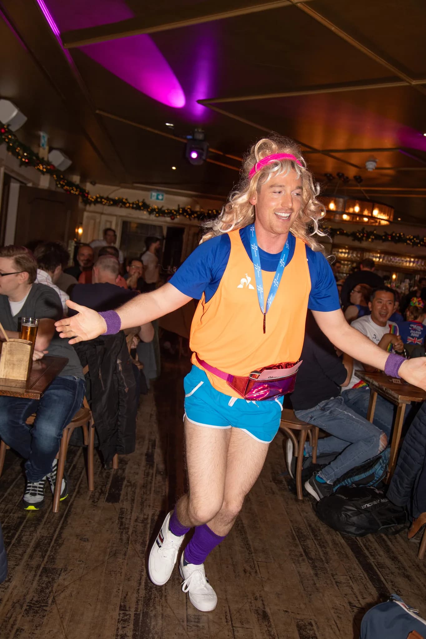 Host mid-jump in the aisle between tables.