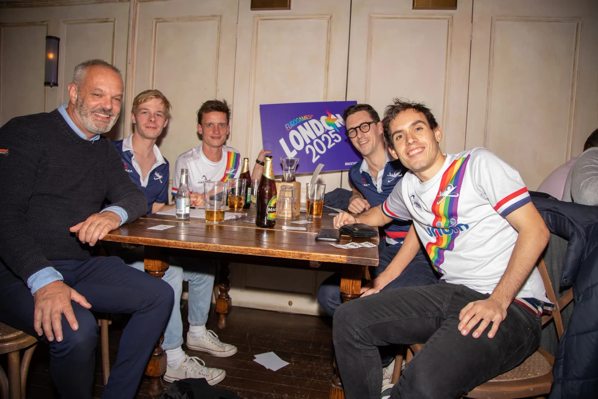 Team smiling for the camera behind a London 2025 sign.