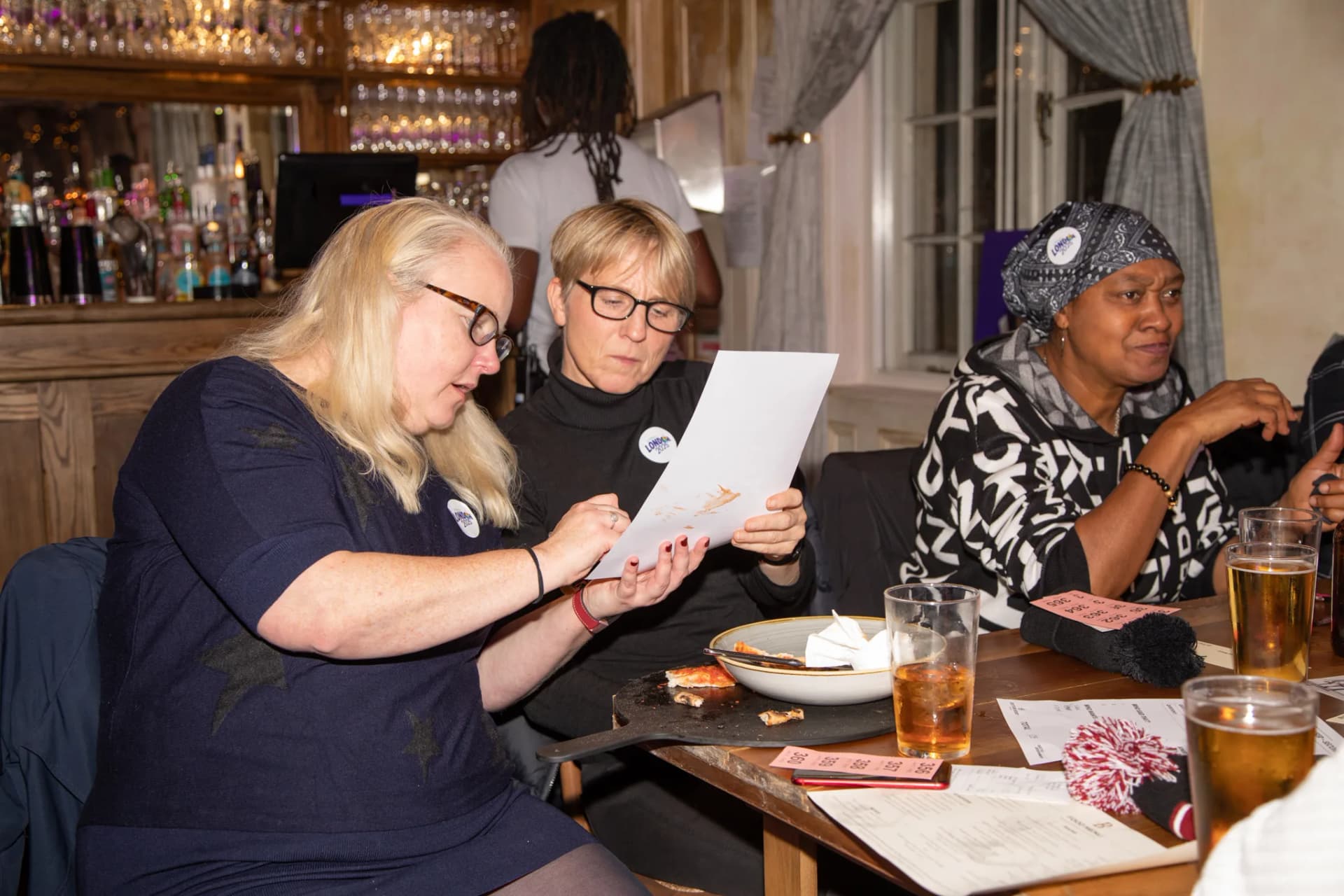 Three players reading a question sheet together.