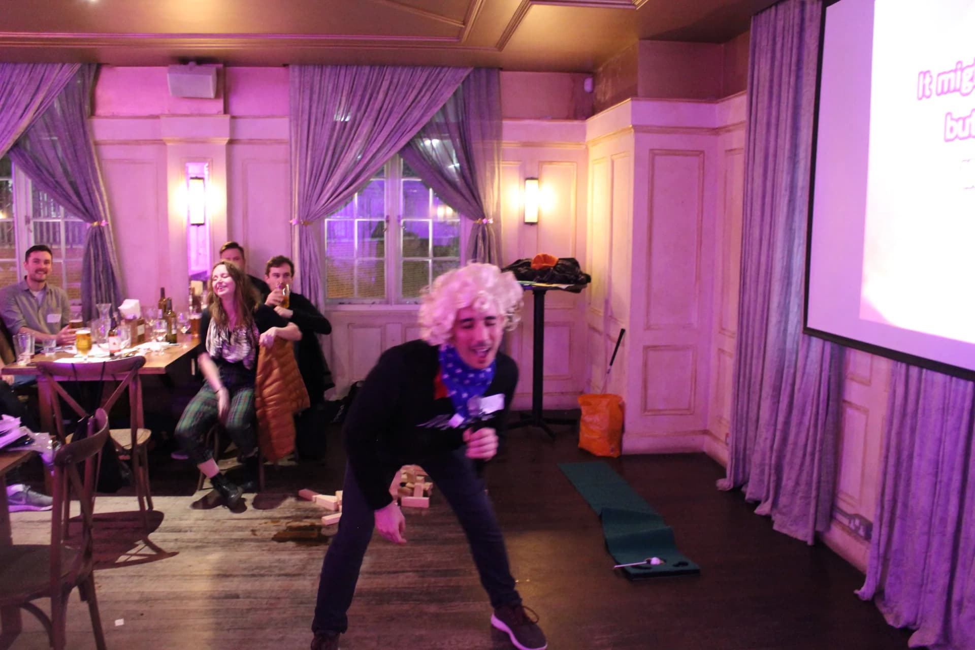 Performer in a curly wig dancing in front of the teams.
