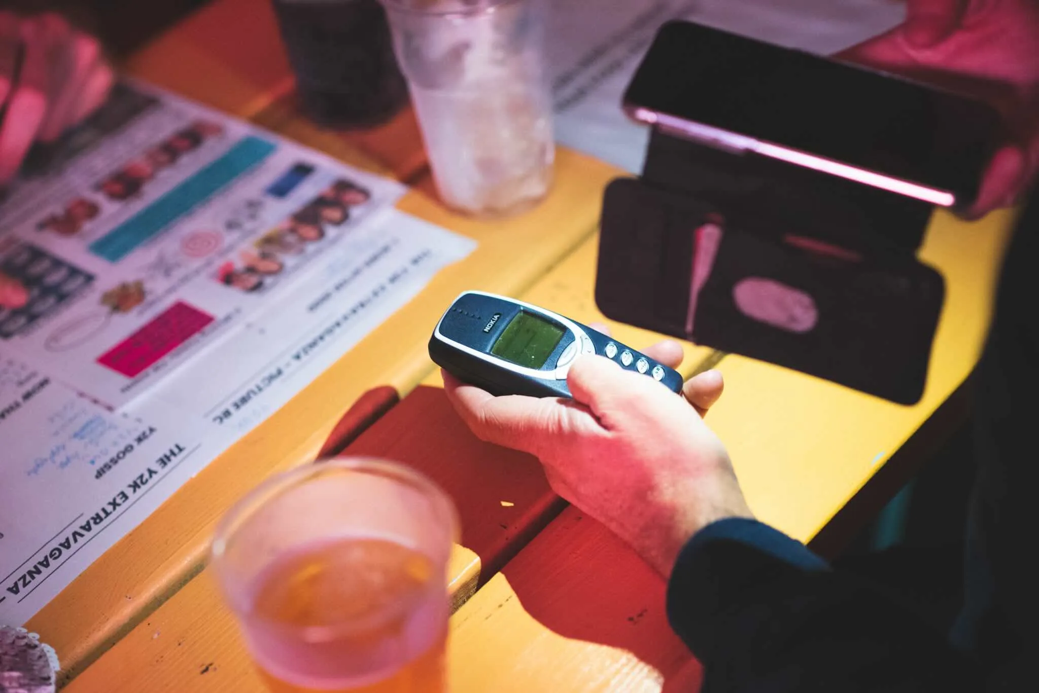 Classic Nokia phone held over the quiz sheet as a Y2K prop.