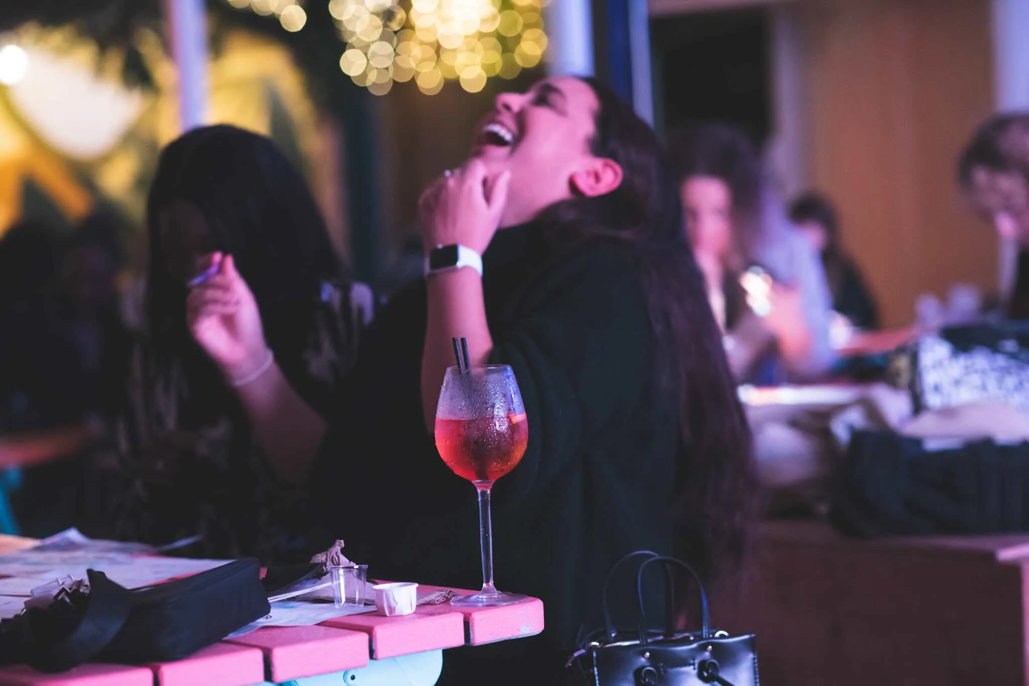 Guest throwing her head back laughing on the terrace.