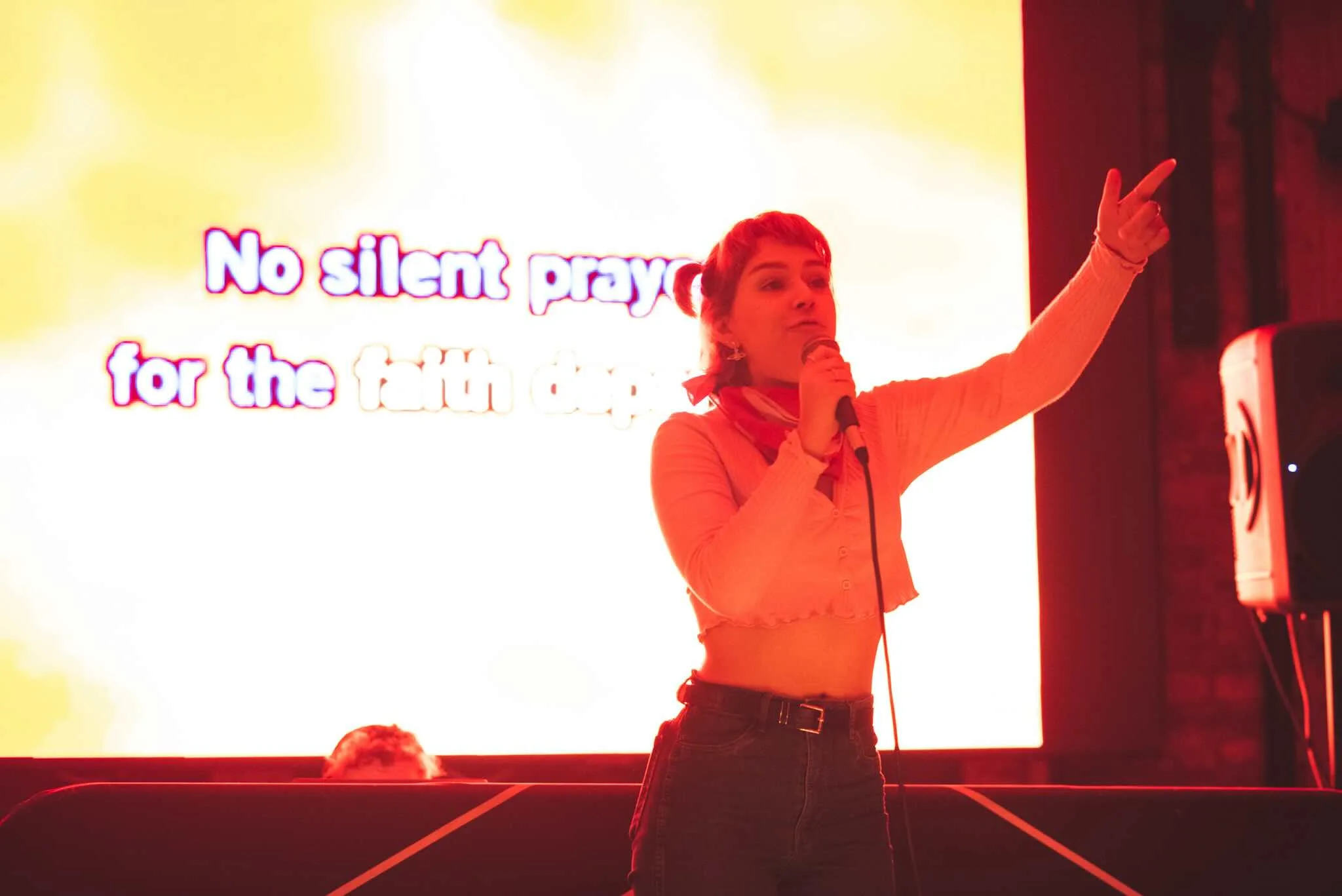 Karaoke singer pointing to the crowd in front of lyrics.