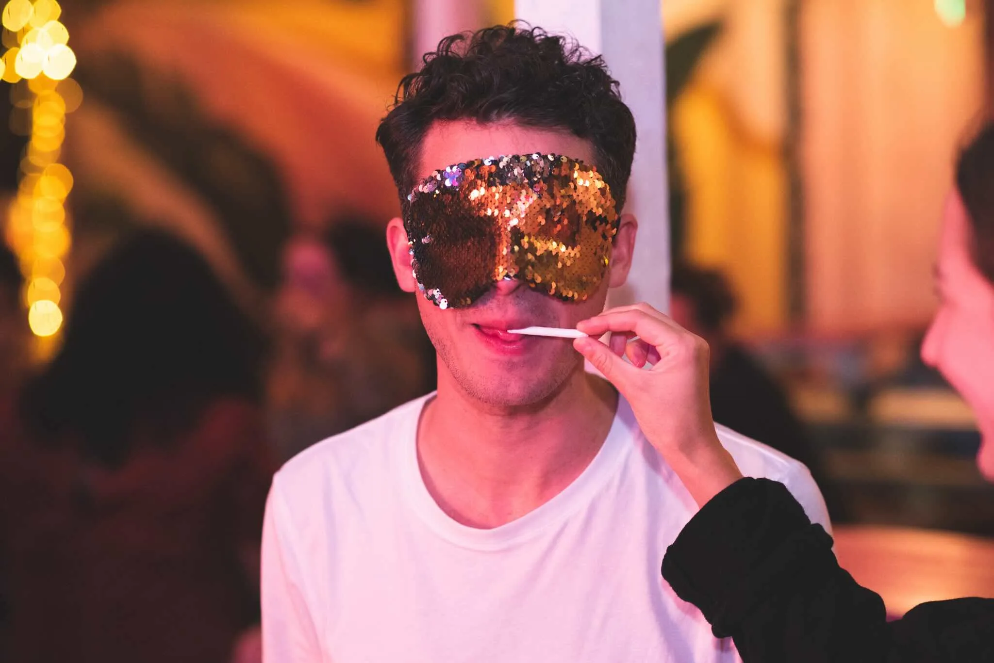 Masked player being fed a taste test sample.