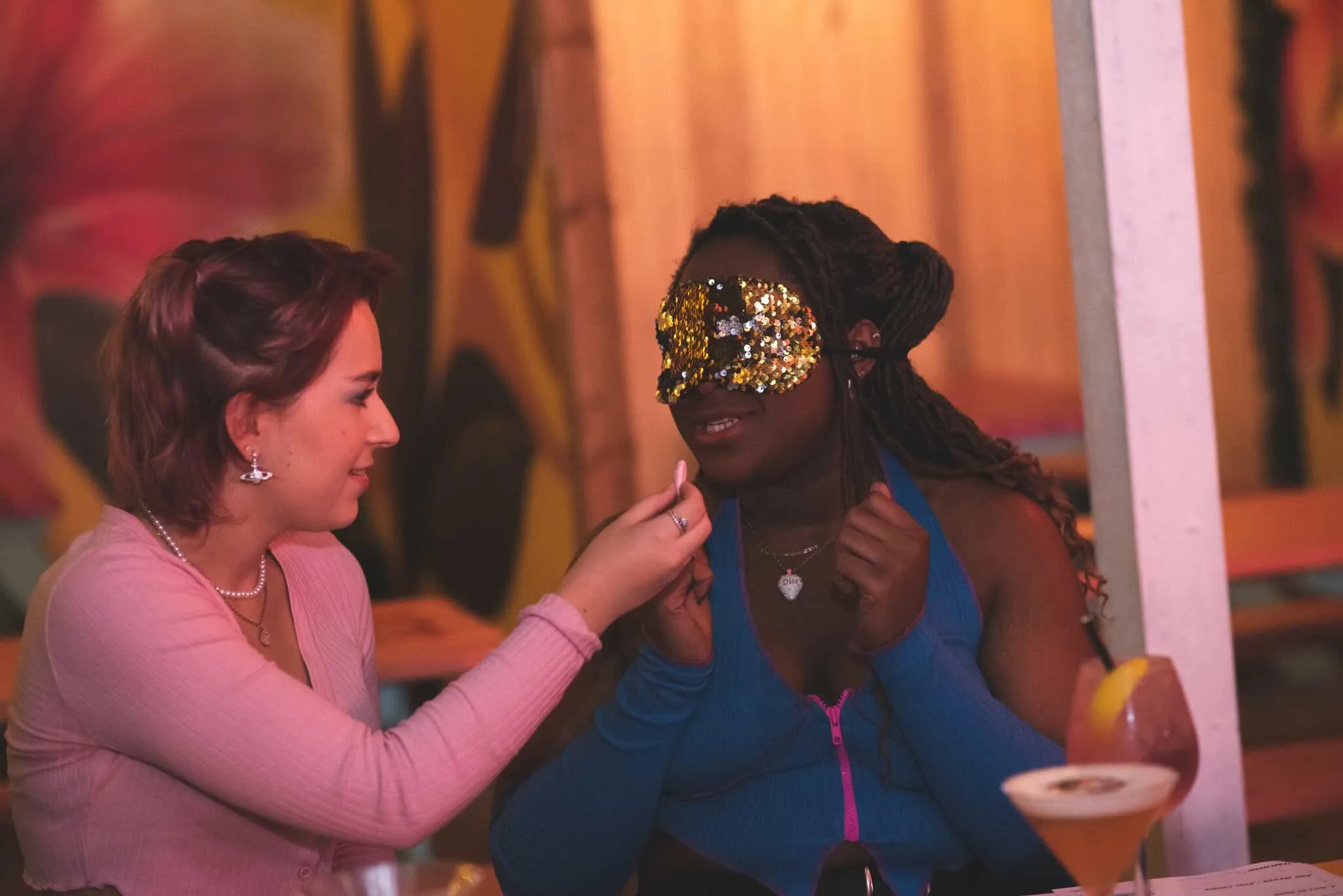 One player feeds a blindfolded teammate a taste test sample.